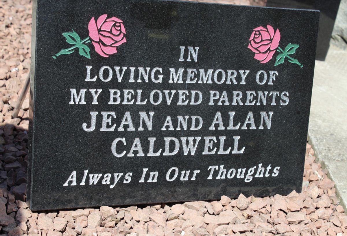 Black granite memorial plaque with carved roses