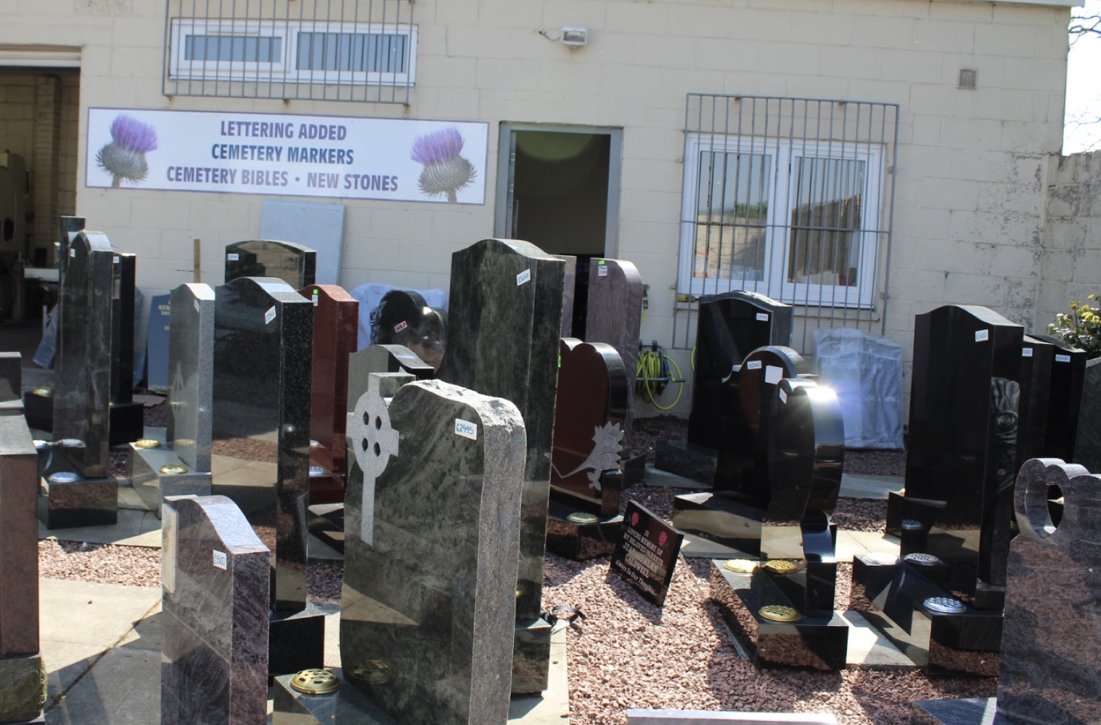 Granite headstones of different shapes and colours on display at the memorial yard in Bishopbriggs